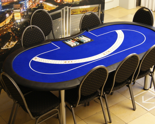 Bild eines Pokertischs, auf dem die Spielkarten aufgefächert sind