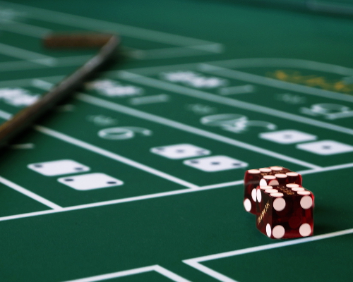 Nahaufnahme von zwei Würfeln und einem Crapsstick auf dem Craps-Tisch